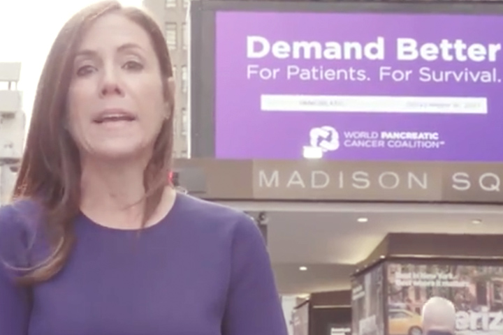 Cindy Gavin of Let's Win in purple in on the street in New York City, in front of Madison Square Garden's marquee that says Demand Better, for World Pancreatic Cancer Day