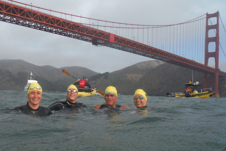 Ed Duncan and his daughters in the water below the Golden Gate Bridge as part of a cross-bay swim