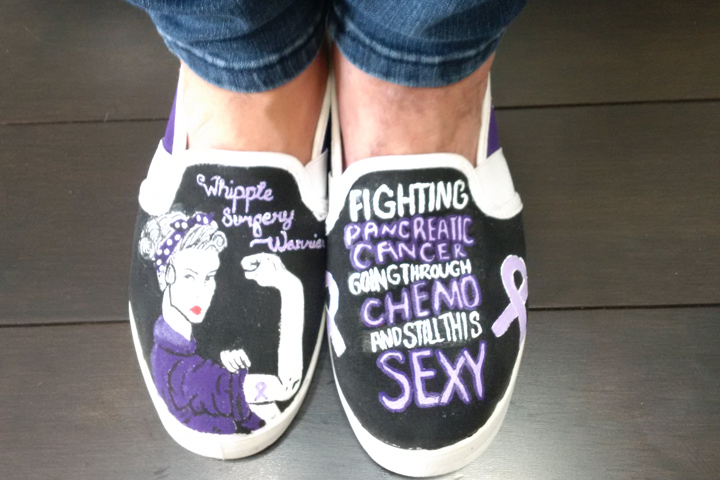 Black sneakers painted with purple sayings to encourage Sandy Robis
