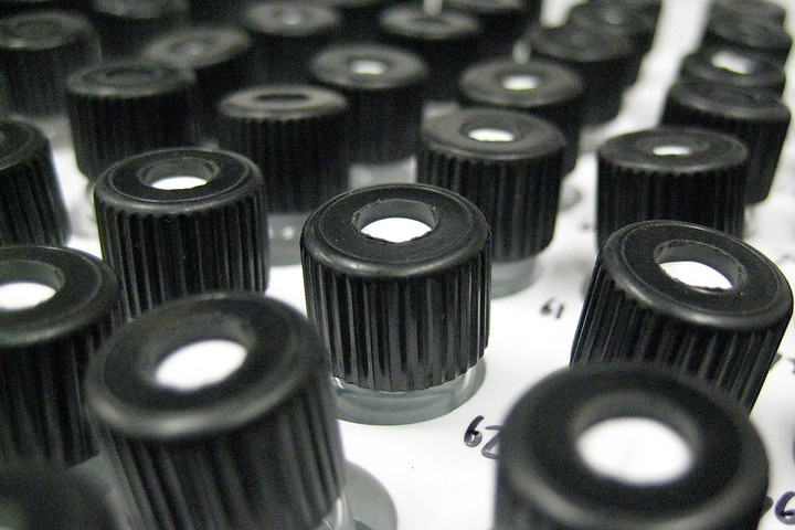 Black and white photo of vials of water with black tops