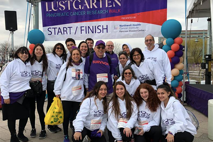 Martin Abrams, in purple with Survivor on his shirt, surrounded by his team at the 2019 Lustgarten Walk