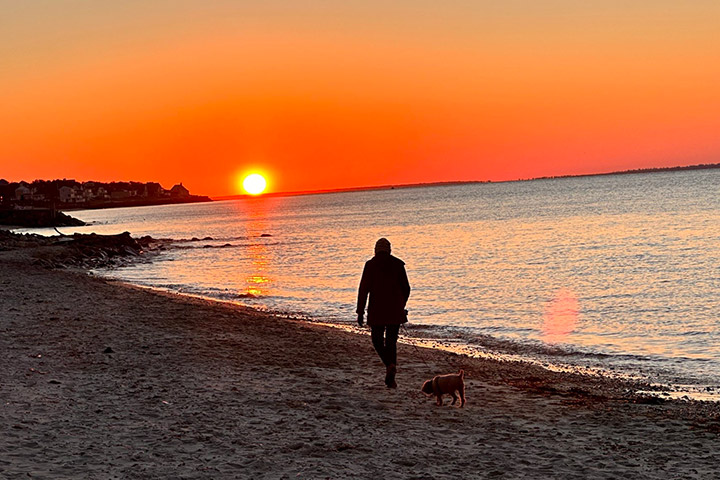 Ann Jaffe walking along a beach at sunset