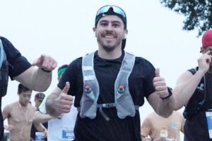A man running a race with two thumbs up